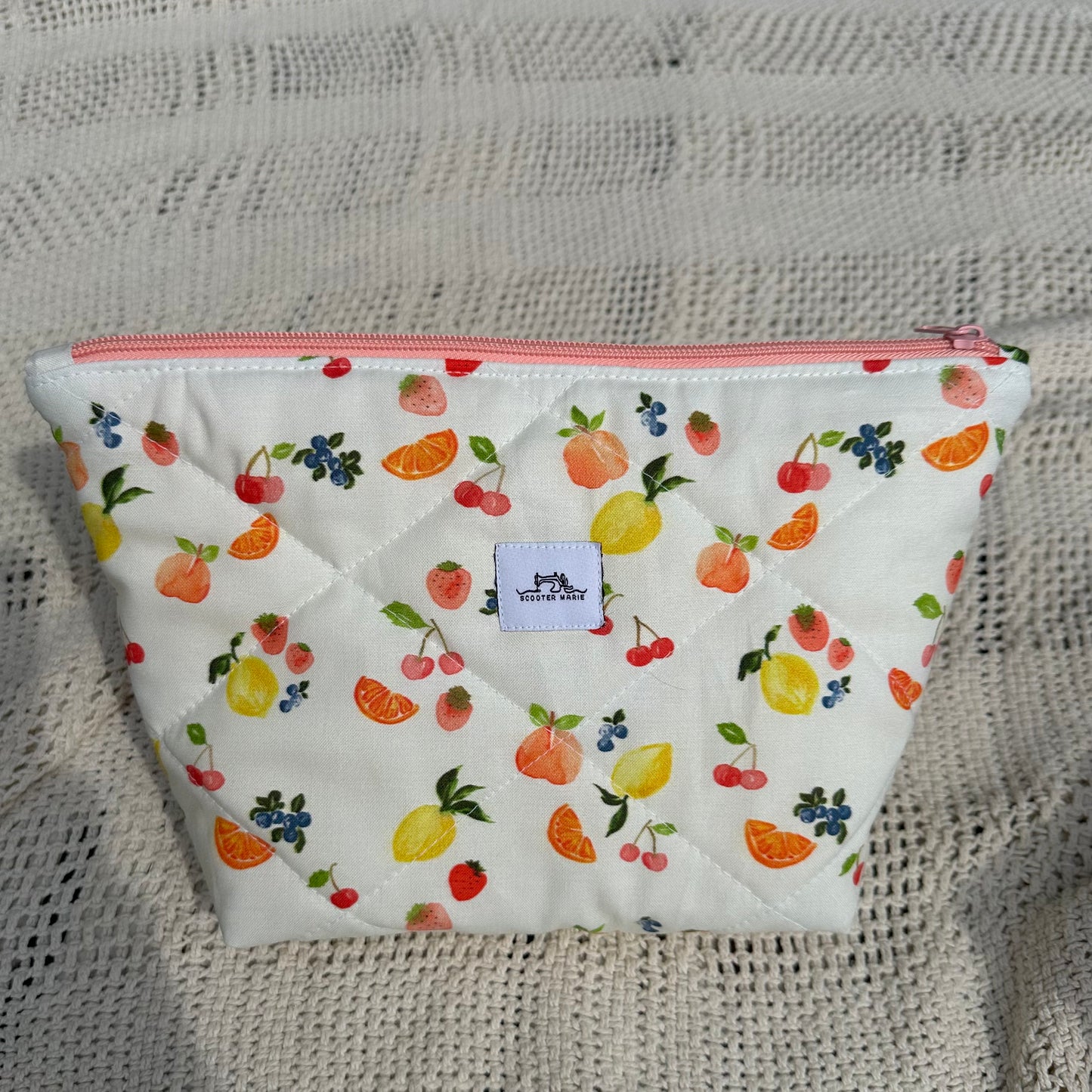 Fabric pouch with fruit pattern on a textured surface