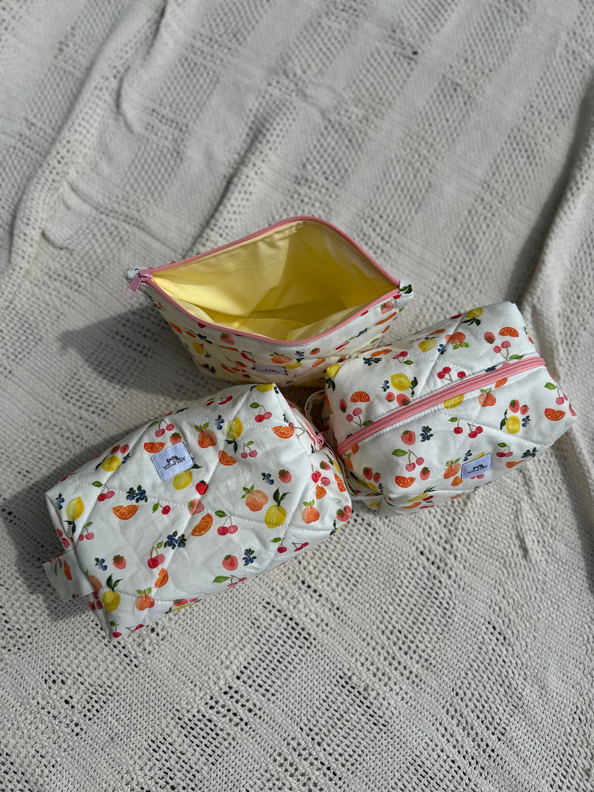 three makeup bags with multicolored fruit patterns. quilted cotton